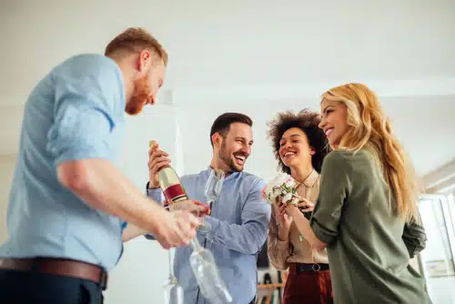 Happy guests arriving at their Airbnb and opening champagne