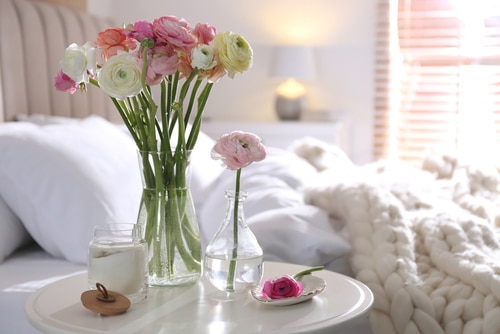 Flowers and a candle on a bedside table