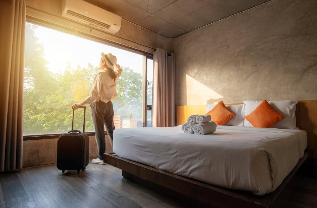 Woman arriving at vacation accommodation and looking out the window