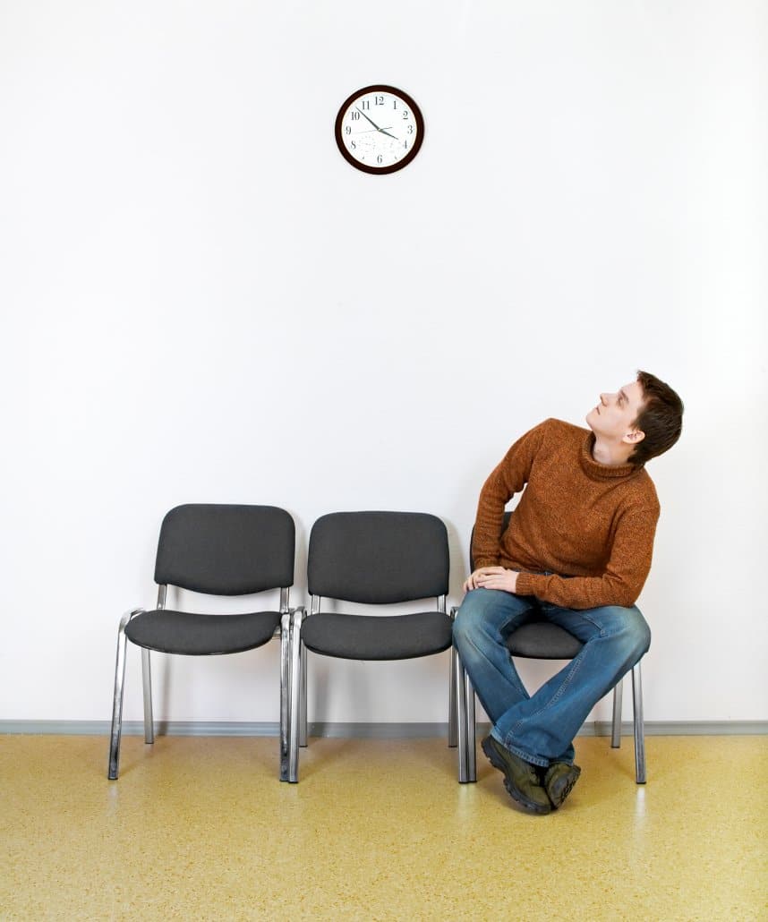 Man looking at clock in waiting room