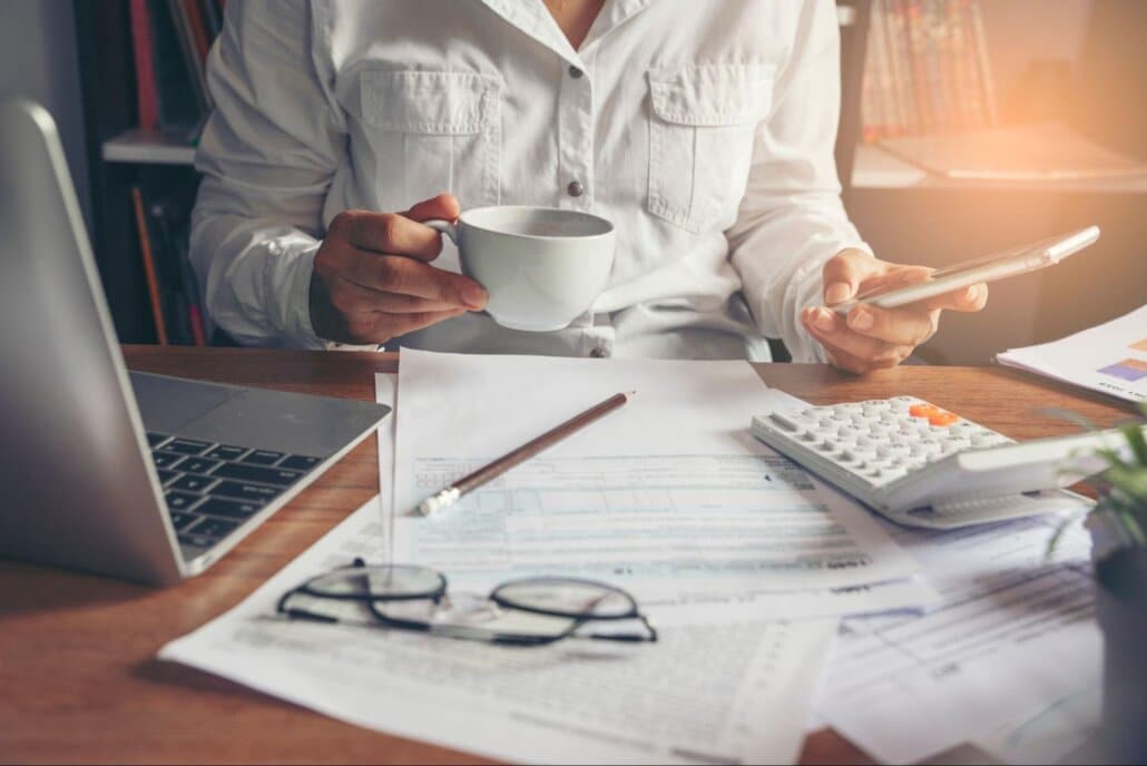 person working at desk with a coffee in his hand