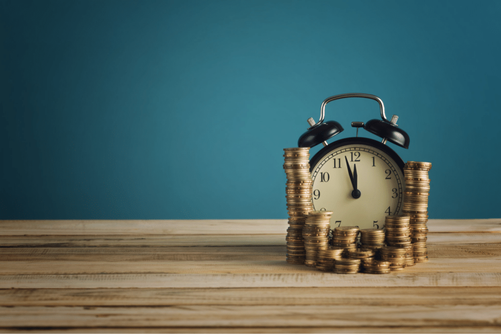 clock surrounded by stacks of coins