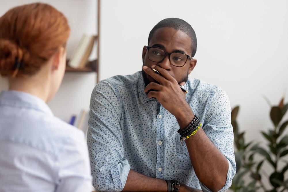 man in meeting with red haired woman