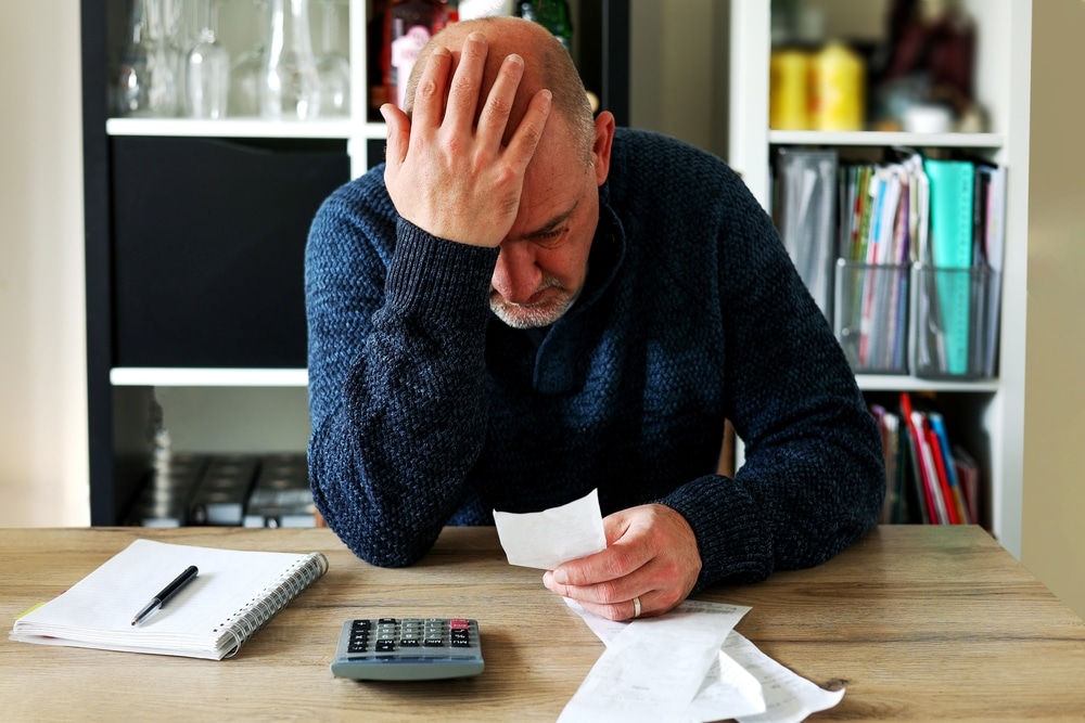 man stressed looking at bills