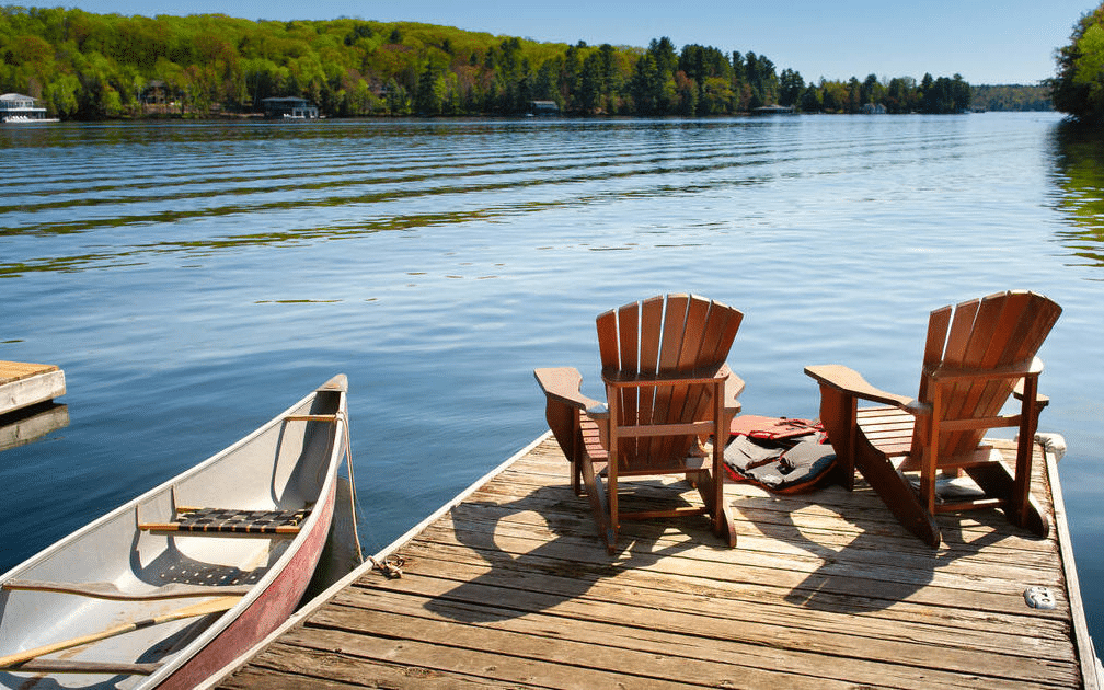 dock with chairs and canoe on lake