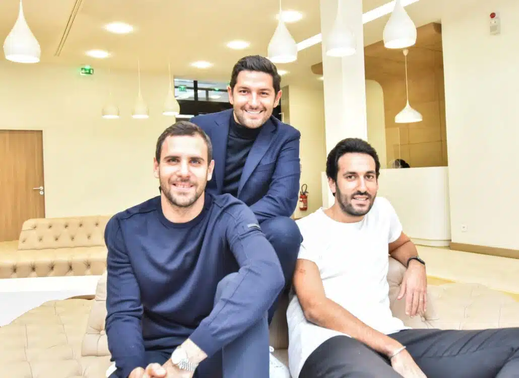 three men smiling in office lobby